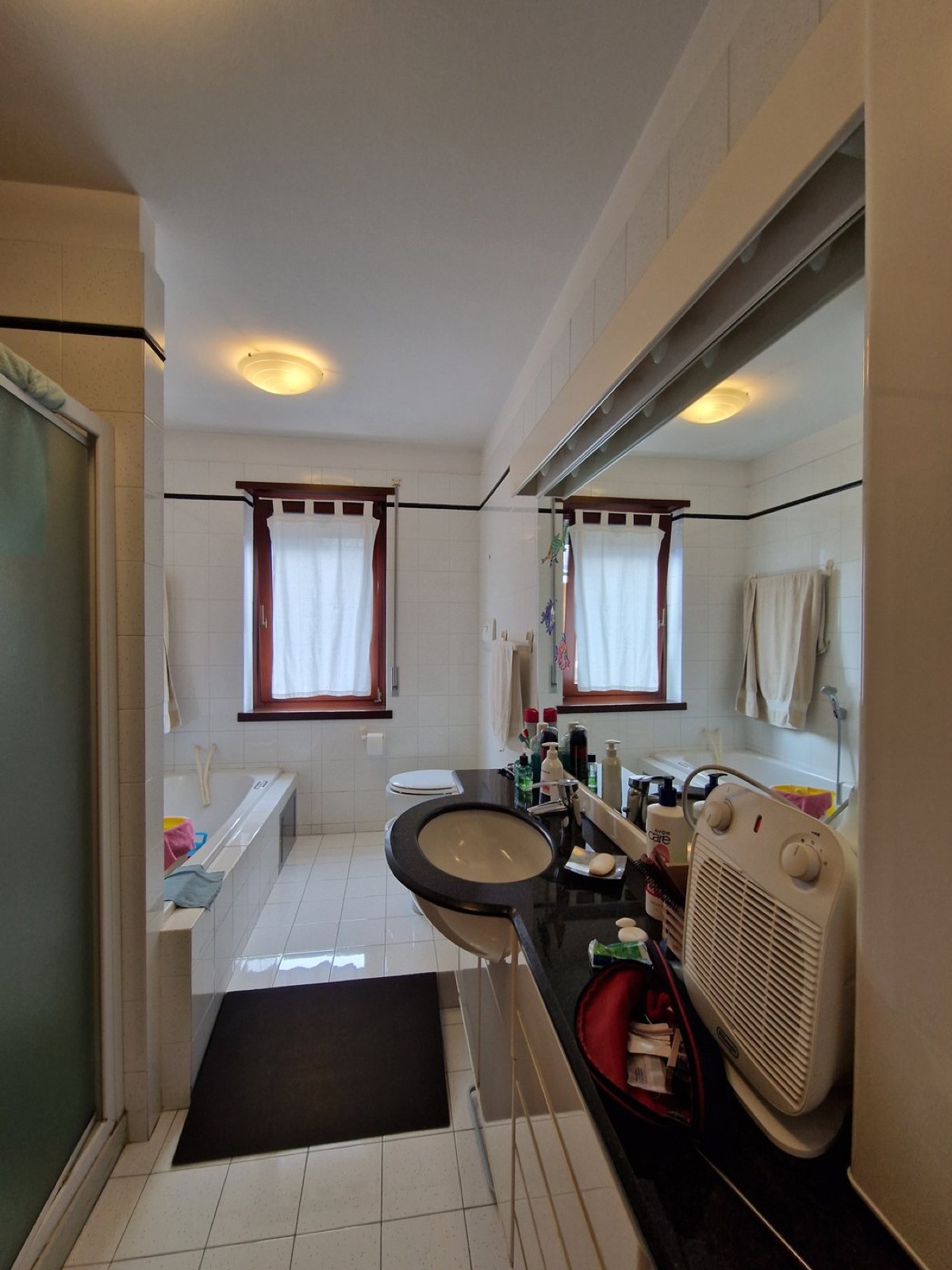 Bagno a Riva del Garda prima dell'intervento con finiture datate e arredi non coordinati
