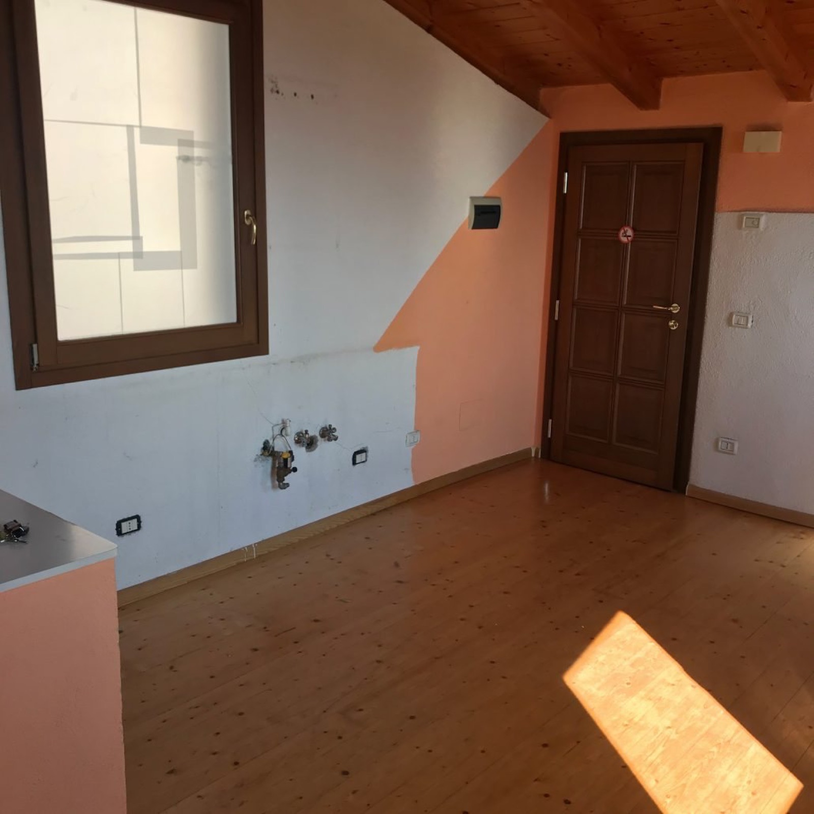 Appartamento vacanze prima dell'intervento con ambiente vuoto e finiture datate