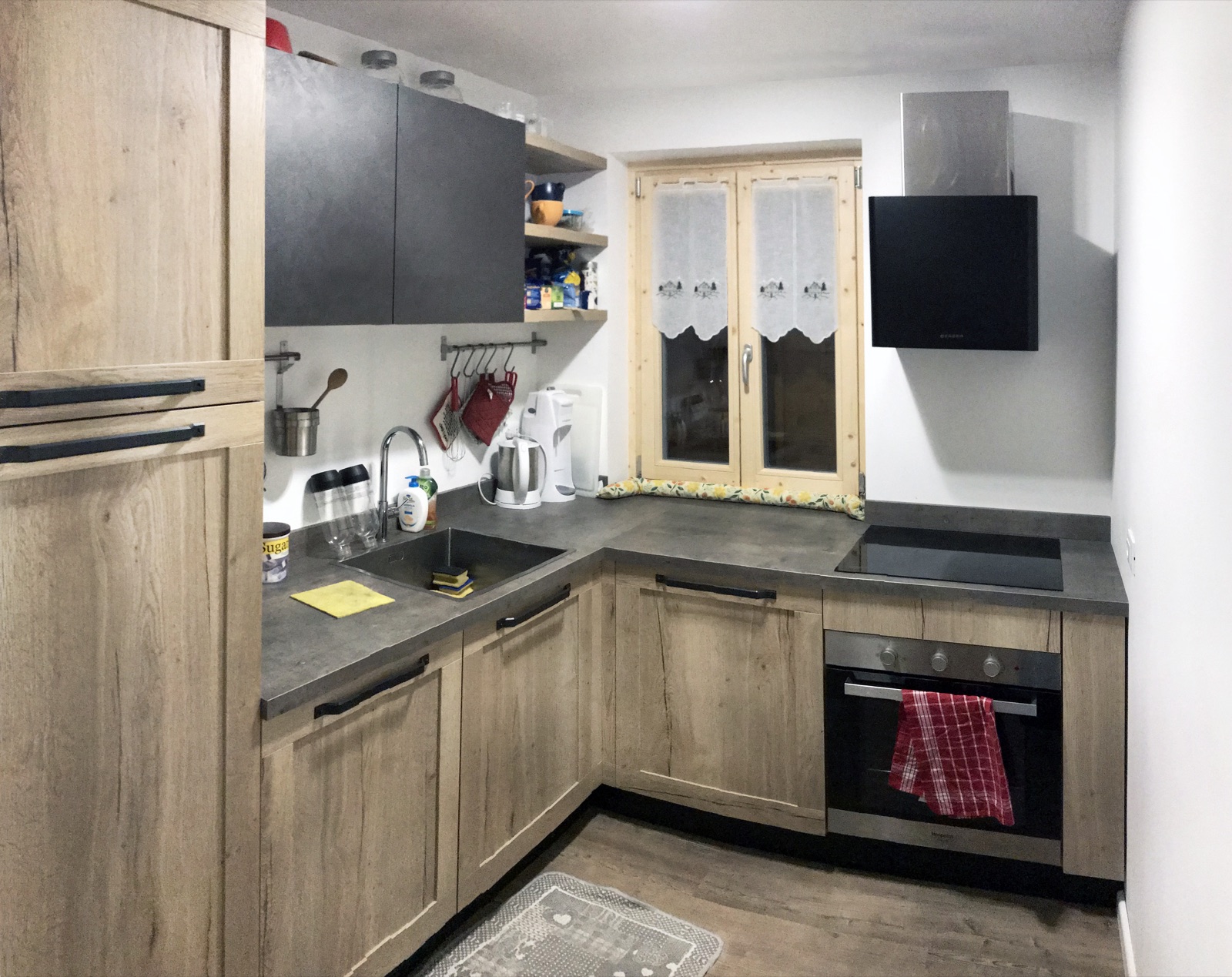 Cucina a Pinzolo dopo l'intervento con composizione su misura, nuova finestra e finiture effetto legno