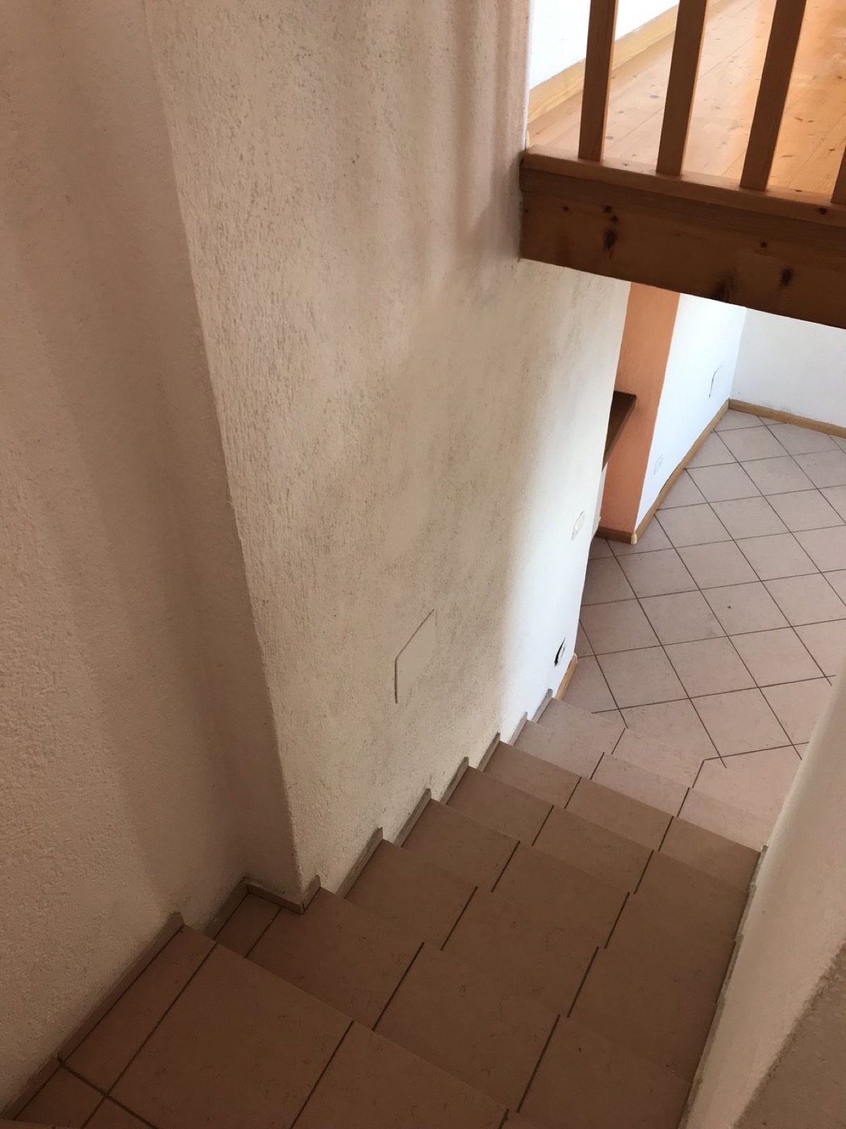 Vano scala a Cologna prima dell'intervento con pareti segnate e finiture datate