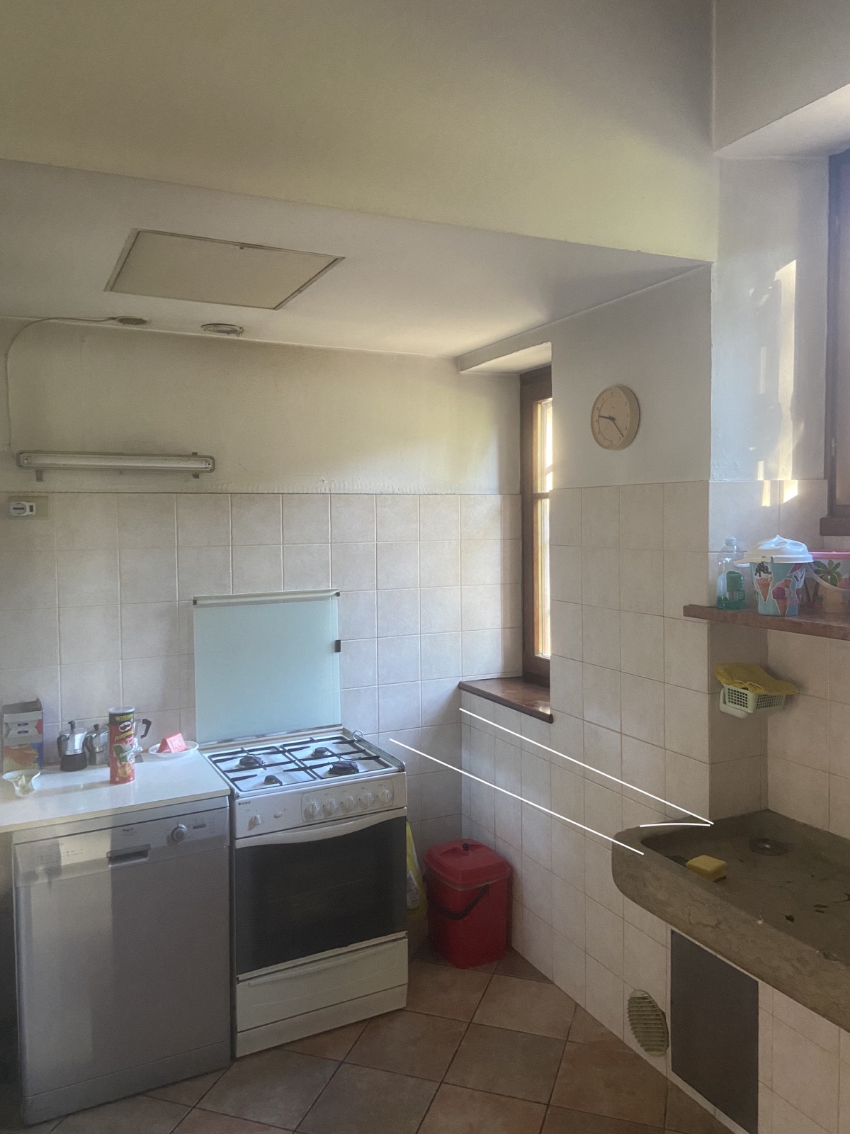 Ambiente Ghielmi a Cadine prima dell'intervento con cucina datata e lavatoio tecnico